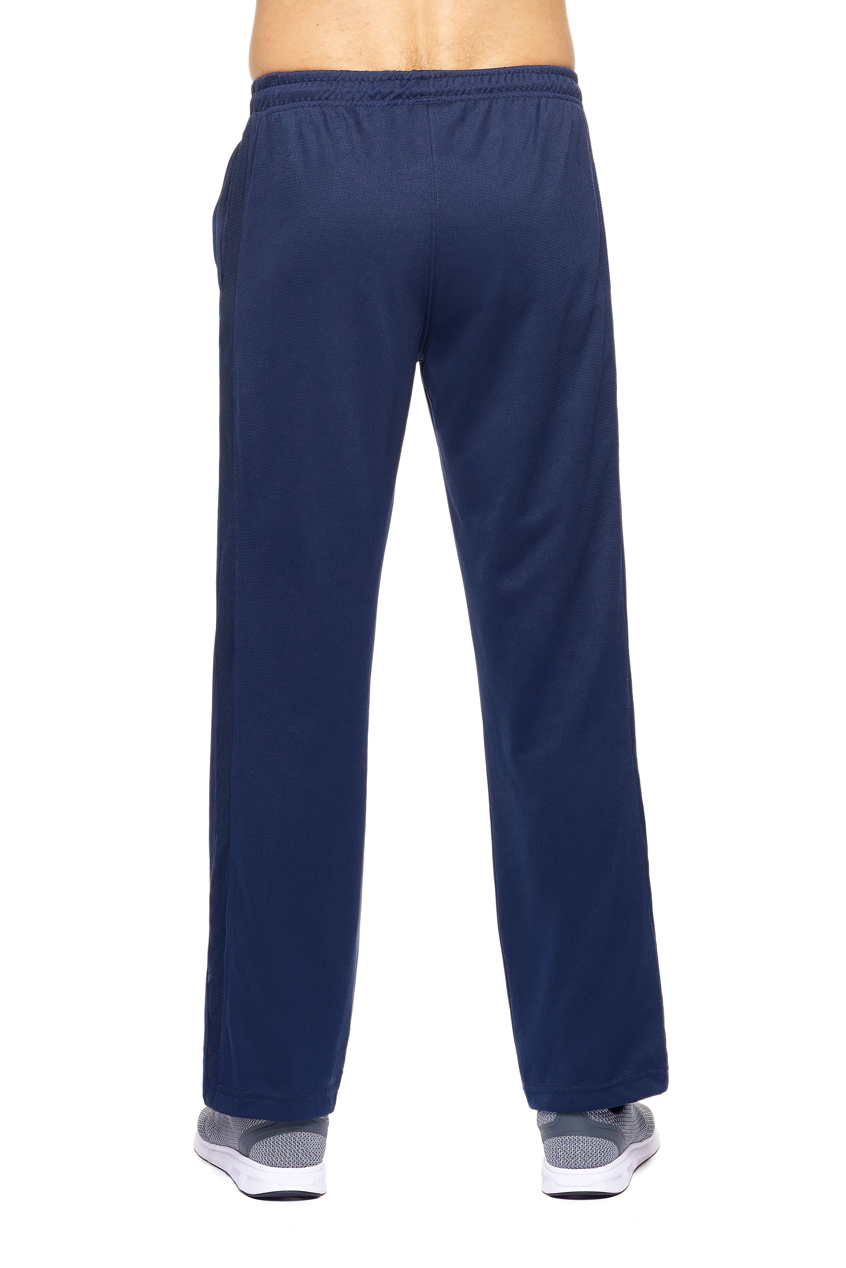 A male model on a white background wearing the men's Sphere City Sport Pants in the color navy made out of 100% polyester showing the relaxed fit from a back view. These pants quick-dry, wick moisture and are made in the USA. #navy