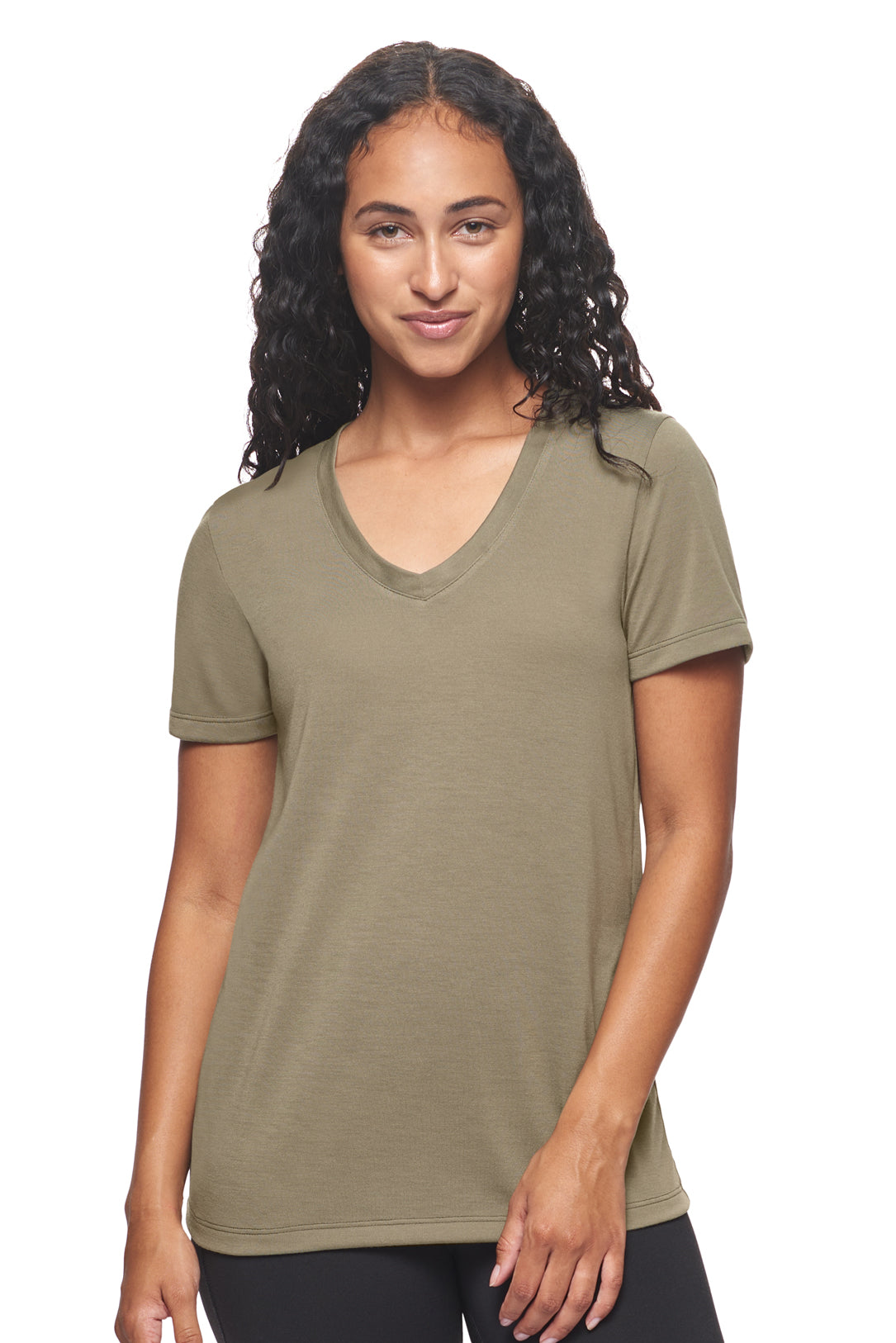 A female model with blonde hair on a white background wearing the women's Siro™ V-Neck Tee in the color olive, made out of 100% snag-free filament polyester, showing the modern fit from a front view. This women's v-neck shirt is breathable, quick-drying, moisture-wicking, and made in the USA. Available in bulk for wholesale purchase. #olive