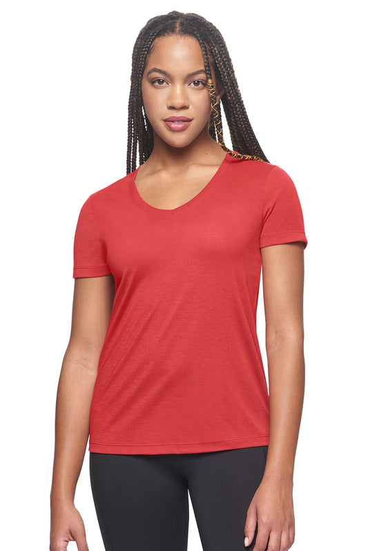 A female model with braids on a white background wearing the women's Siro™ V-Neck Tee in the color scarlet red, made out of 100% snag-free filament polyester, showing the modern fit from a front view. This women's v-neck shirt is breathable, quick-drying, moisture-wicking, and made in the USA. Available in bulk for wholesale purchase. #scarlet