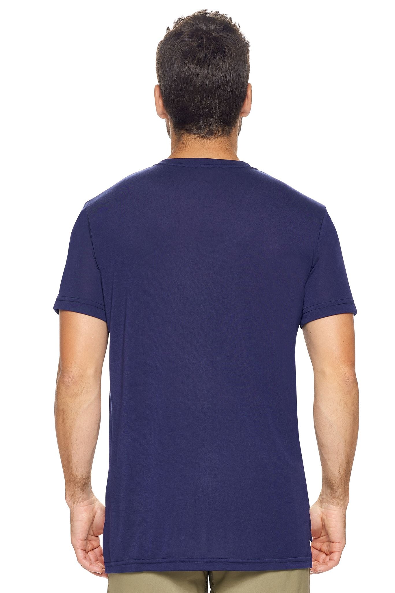 A male model with brown hair on a white background wearing the men's Siro™ Drop Tail Henley in the color navy, made out of 100% polyester, showing the relaxed fit from a back view. This 3-button shirt features snag-free filament technology, is super soft, breathable, quick-drying, moisture-wicking, and made in the USA. #navy