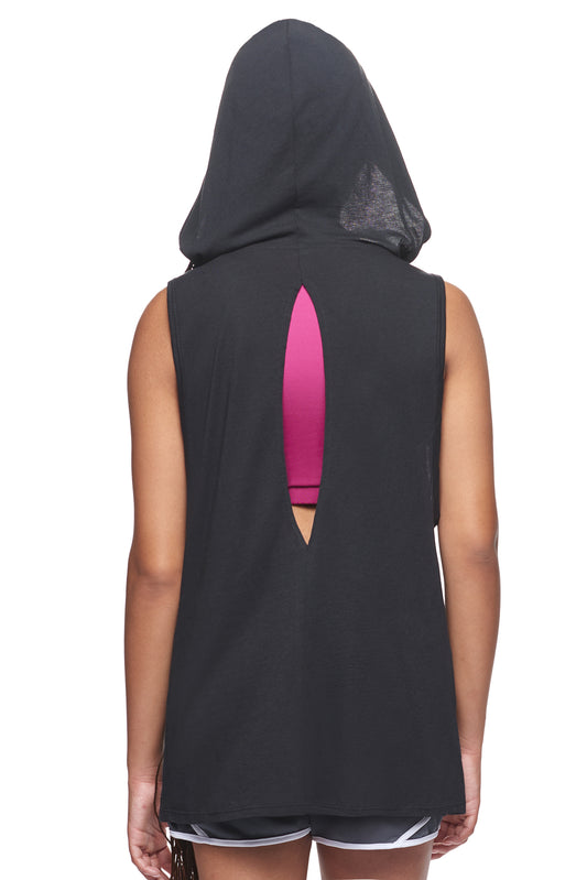 A female model with braided hair wearing the women's MoCA Sleeveless Hoodie  in the color black, made from a luxurious blend of 50% LENZING Modal and 50% Combed Ring-Spun Cotton, showing the relaxed fit from a back view, hood up. This hoodie tank shirt is elevated, eco-friendly, made in the USA, and available for bulk purchase. #black