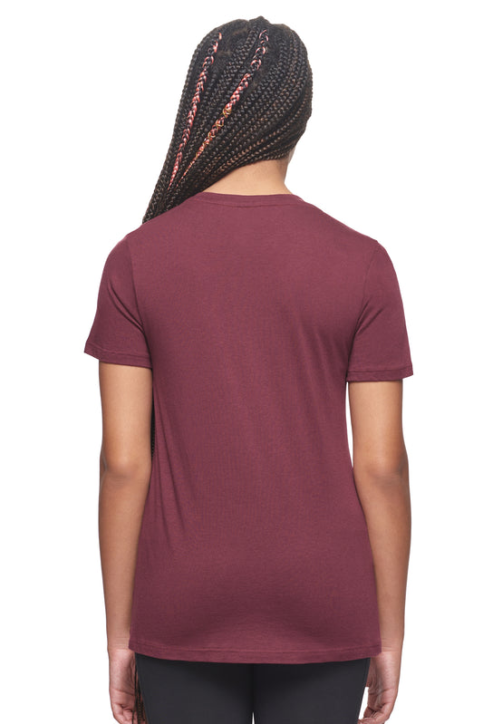 A female model with braided hair wearing the Women's MoCA V-Neck Tee in the color maroon, made from a luxurious blend of 50% LENZING Modal and 50% Combed Ring-Spun Cotton, showing the relaxed feminine fit from a back view. This fashion-forward, more sustainable t-shirt is elevated, eco-friendly, made in the USA, and available for bulk purchase. #maroon