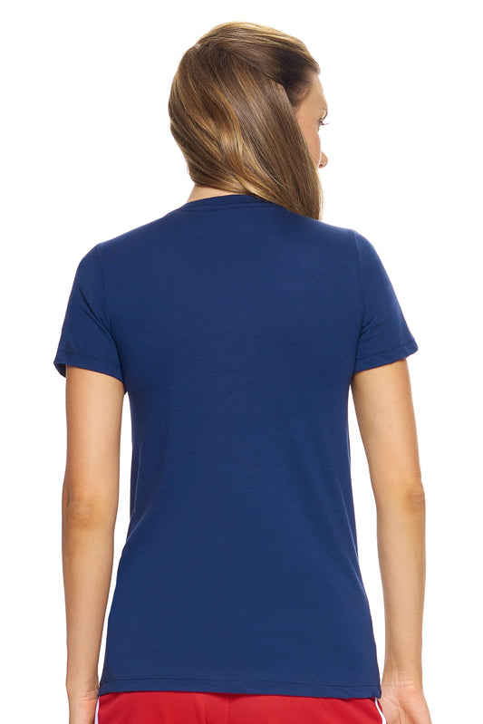 A female model with brown hair wearing the women's MoCA Bay Crewneck Tee in the color navy, made from a luxurious blend of 50% LENZING Modal and 50% Combed Ring-Spun Cotton, showing the feminine fit from a back view. This shirt is elevated, eco-friendly, made in the USA, and available for bulk purchase. #navy