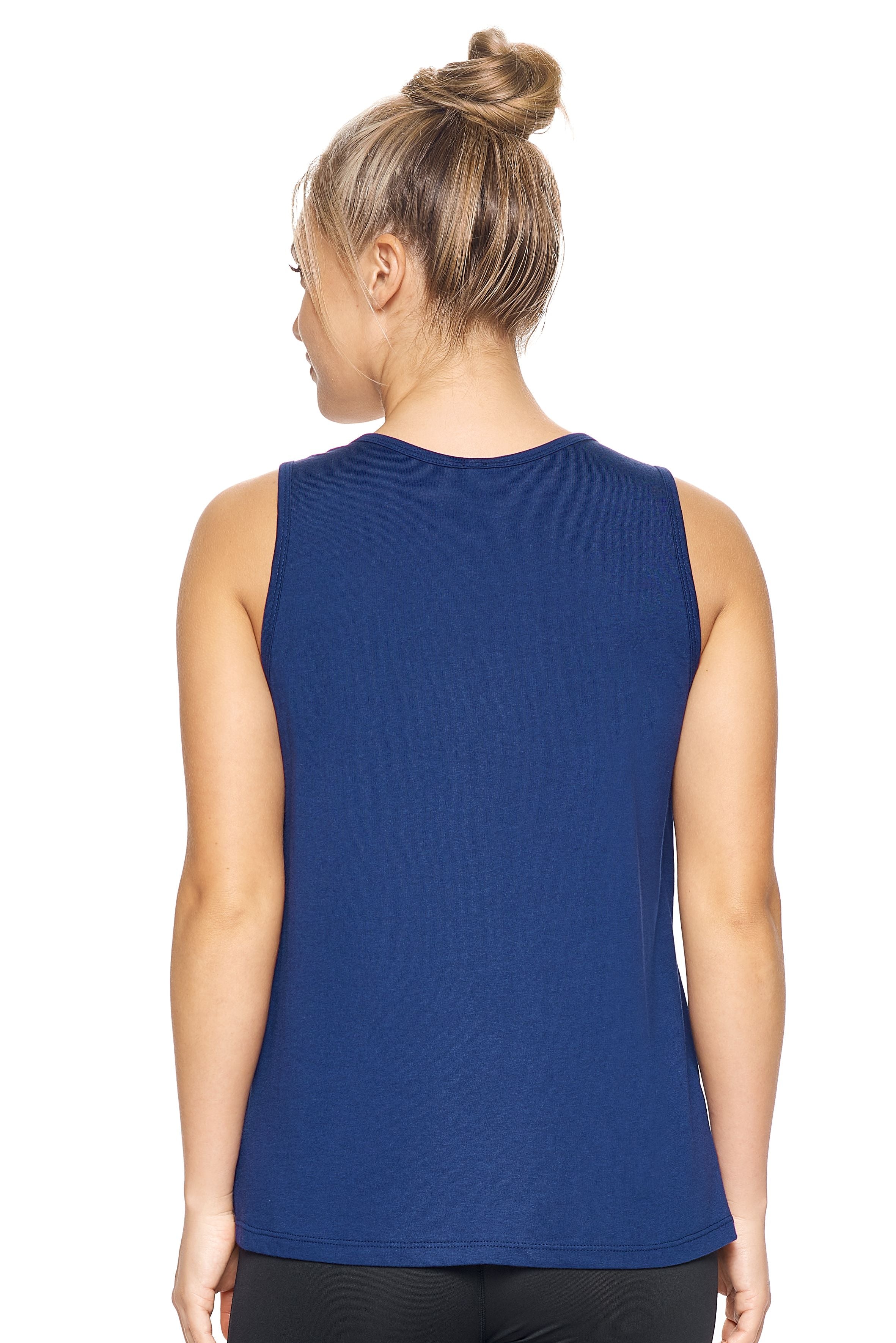 A female model with blonde hair wearing the women's MoCA Tie Front Tank Tee in the color navy, made from a luxurious blend of 50% LENZING Modal and 50% Combed Ring-Spun Cotton, showing the relaxed fit from a back view. This fashion-forward, more sustainable t-shirt is elevated, eco-friendly, made in the USA, and available for bulk purchase. #navy
