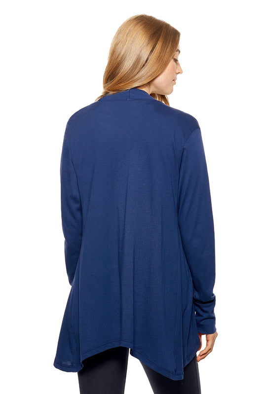 A female model with red hair wearing the women's MoCA Drape Front Cardigan in the color navy blue, made from a luxurious blend of 50% LENZING Modal and 50% Combed Ring-Spun Cotton, showing the relaxed fit from a back view. This fashion-forward, more sustainable top is elevated, eco-friendly, made in the USA, and available for bulk purchase. #navy