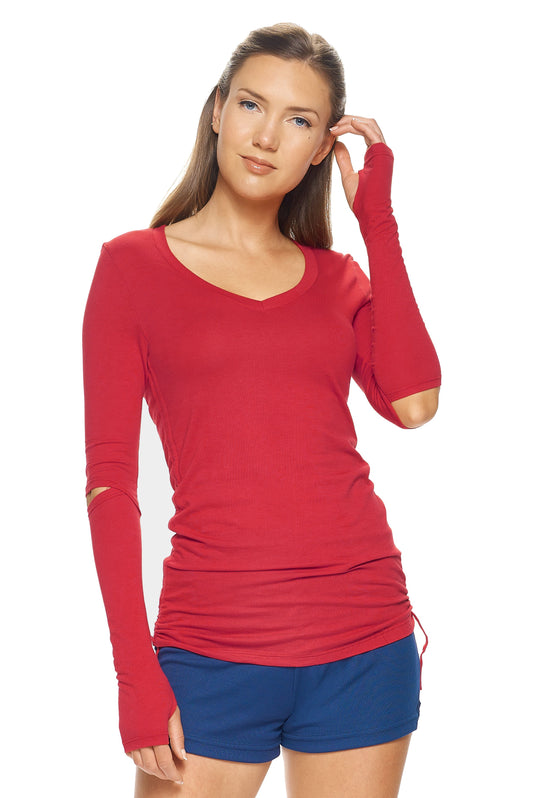 A female model with brown hair wearing the Women's MoCA Laurel Long Sleeve V-Neck Tee in the color scarlet, made from a luxurious blend of 50% LENZING Modal and 50% Combed Ring-Spun Cotton, showing the feminine fit from a front view. This fashion-forward, more sustainable t-shirt is elevated, eco-friendly, made in the USA, and available for bulk purchase. #scarlet