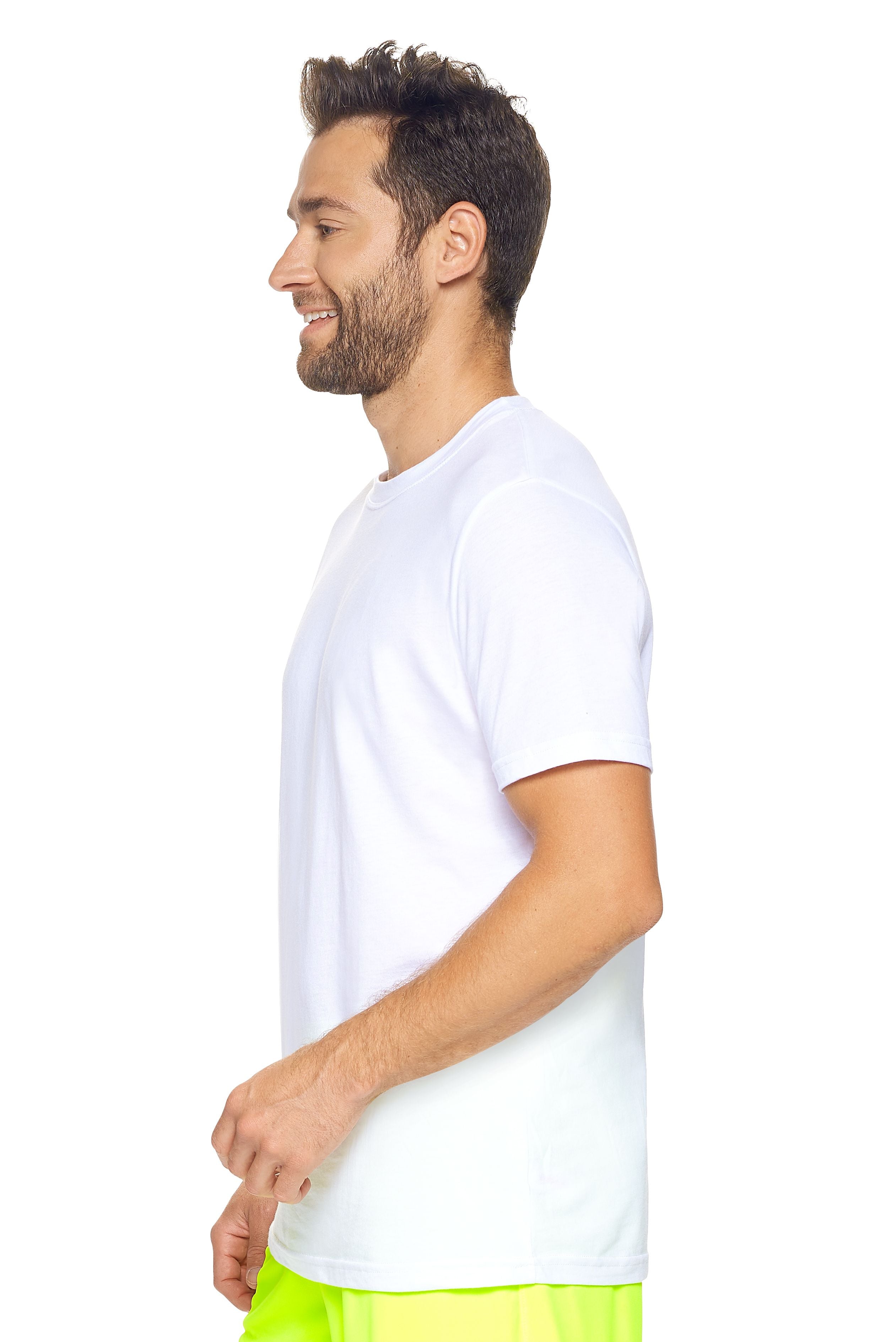 A male model with brown hair wearing the Men's MoCA V-Neck Tee in the color white, made from a luxurious blend of 50% LENZING Modal and 50% Combed Ring-Spun Cotton, showing the relaxed fit from a side view. This fashion-forward, more sustainable t-shirt is elevated, eco-friendly, made in the USA, and available for bulk purchase. #white