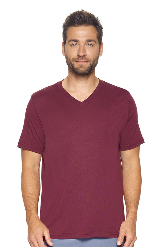 A male model with curly hair wearing the Men's MoCA V-Neck Tee in the color maroon, made from a luxurious blend of 50% LENZING Modal and 50% Combed Ring-Spun Cotton, showing the relaxed fit from a front view. This fashion-forward, more sustainable t-shirt is elevated, eco-friendly, made in the USA, and available for bulk purchase. #maroon