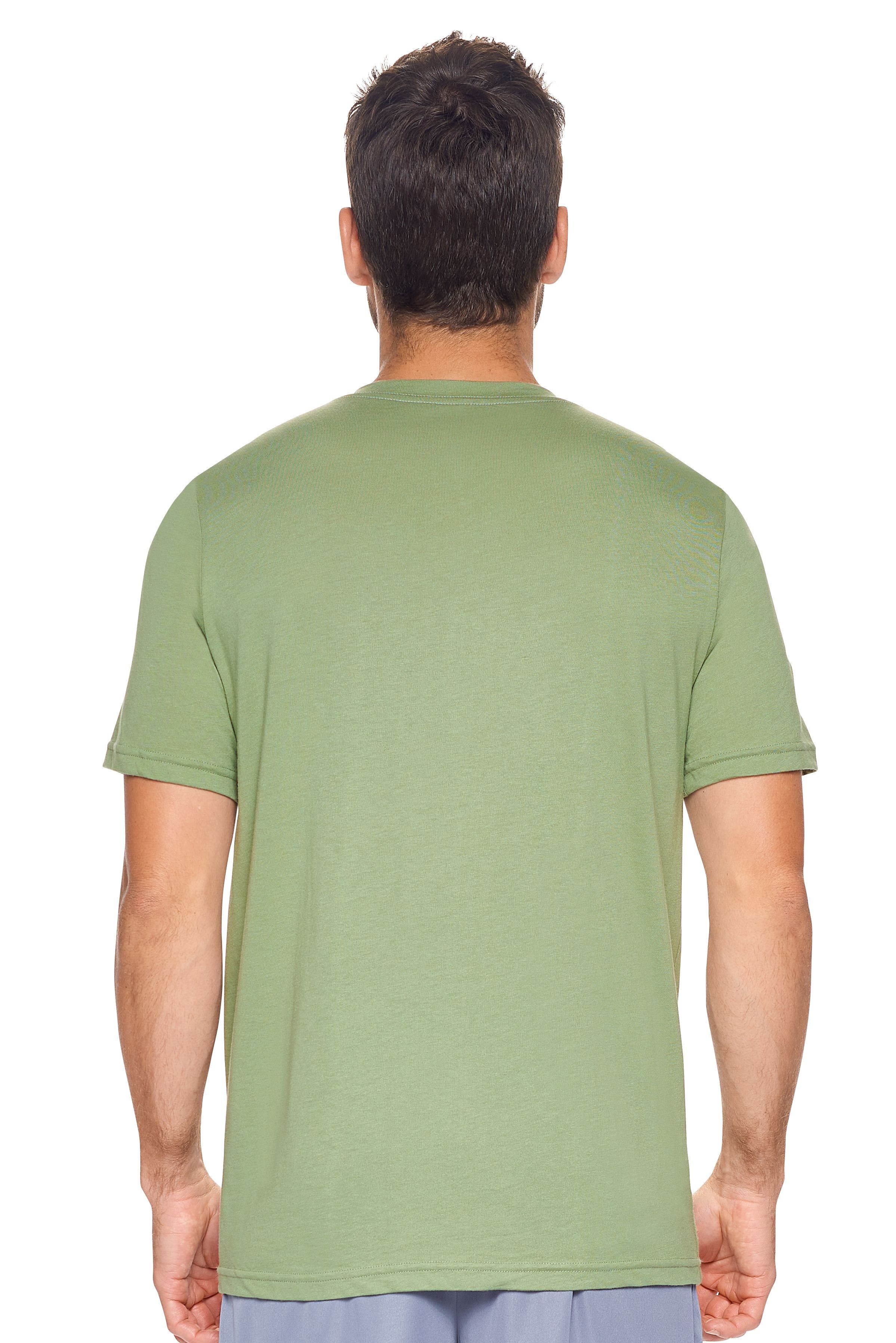 A male model with curly hair wearing the Men's MoCA V-Neck Tee in the color meadow, made from a luxurious blend of 50% LENZING Modal and 50% Combed Ring-Spun Cotton, showing the relaxed fit from a back view. This fashion-forward, more sustainable t-shirt is elevated, eco-friendly, made in the USA, and available for bulk purchase. #meadow