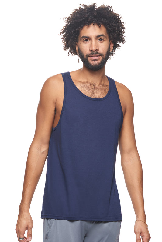 A male model with curly hair wearing the men's MoCA Sleeveless Tank in the color navy, made from a luxurious blend of 50% LENZING Modal and 50% Combed Ring-Spun Cotton, showing the relaxed fit from a front view. This tank is elevated, eco-friendly, made in the USA, and available for bulk purchase. #navy