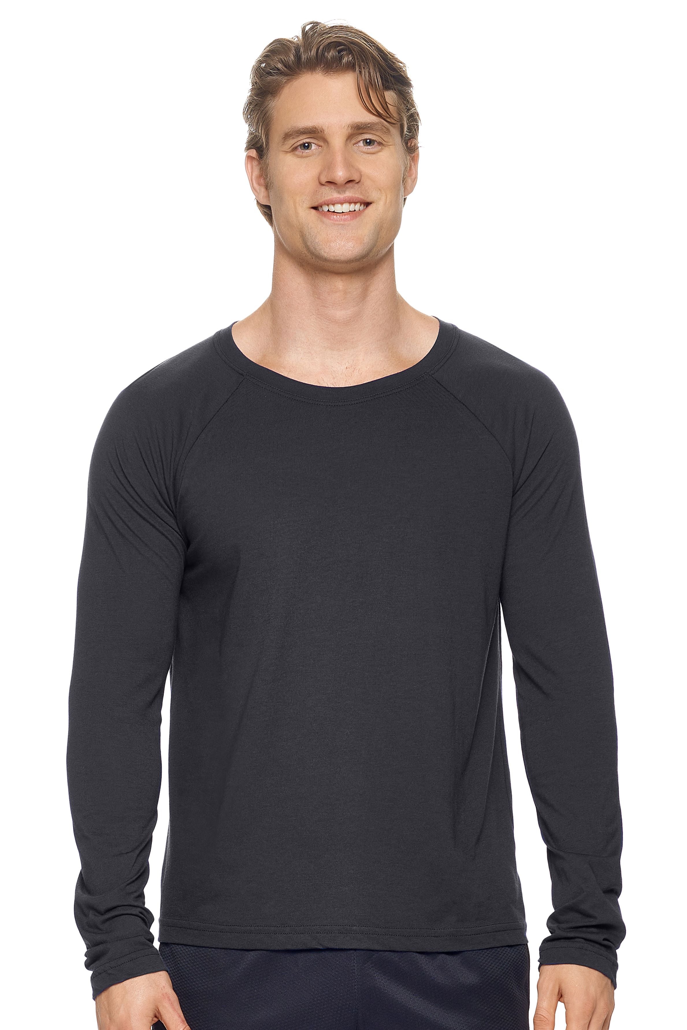 A male model with dirty blonde hair wearing the men's MoCA Long Sleeve Raglan Tee in the color black, made from a luxurious blend of 50% LENZING Modal and 50% Combed Ring-Spun Cotton, showing the relaxed fit from a front view. This shirt is elevated, eco-friendly, made in the USA, and available for bulk purchase. #black