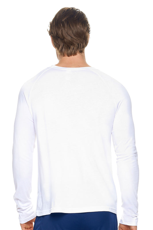 A male model with dirty blonde hair wearing the men's MoCA Long Sleeve Raglan Tee in the color white, made from a luxurious blend of 50% LENZING Modal and 50% Combed Ring-Spun Cotton, showing the relaxed fit from a back view. This shirt is elevated, eco-friendly, made in the USA, and available for bulk purchase. #white