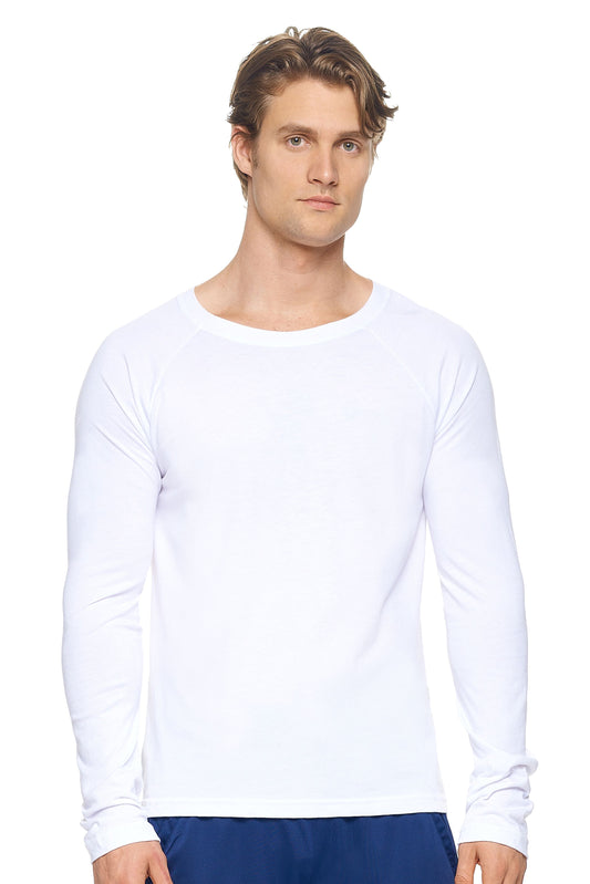 A male model with dirty blonde hair wearing the men's MoCA Long Sleeve Raglan Tee in the color white, made from a luxurious blend of 50% LENZING Modal and 50% Combed Ring-Spun Cotton, showing the relaxed fit from a front view. This shirt is elevated, eco-friendly, made in the USA, and available for bulk purchase. #white
